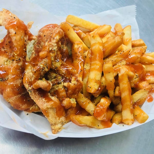 Harold's Chicken #41 fried chicken and french fries, both drizzled with mild sauce and pepper.
