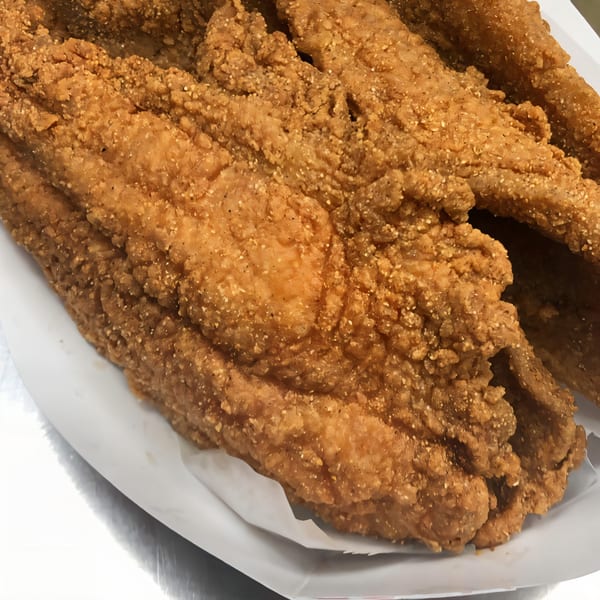 Close-up of several pieces of golden-brown fried catfish from Harold's Chicken #41.
